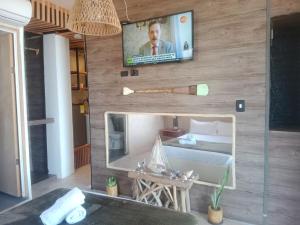 a room with a mirror and a tv on a wall at Apart MCKELLER in Cueva de Morgan