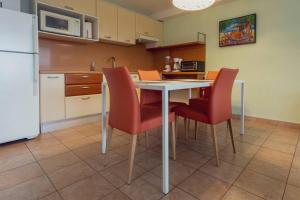 a kitchen with a table and chairs and a refrigerator at Sublime Stay - Royal Retreats at Maho Beach in Lowlands +30 photos