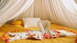 a bed with two swans made out of towels at Akumal Natura Glamping in Akumal