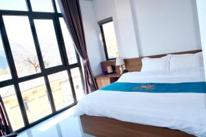 Un dormitorio con una cama y una ventana grande en Snow Hotel, en Mèo Vạc