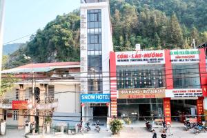 Un gran edificio con motocicletas estacionadas frente a él. en Snow Hotel, en Mèo Vạc