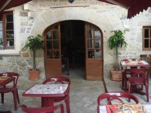 un restaurante con mesas y sillas y un edificio de piedra en Hotel Des Arts, en Puybrun