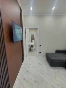 une chambre avec un lit et une télévision à écran plat dans l'établissement Soonun elit, à Bishkek