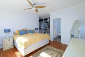 Un dormitorio con una cama y un ventilador de techo. en Royal House, en Muizenberg 15 fotos más