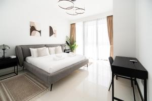 een witte slaapkamer met een bed en een bureau bij Beachfront, Perfect sea view, Private beach access, 2-BDR in Dubai