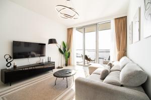een woonkamer met een bank en een tv bij Beachfront, Perfect sea view, Private beach access, 2-BDR in Dubai