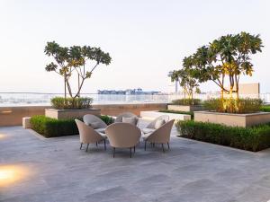 een terras met een tafel, stoelen en bomen bij Beachfront, Perfect sea view, Private beach access, 2-BDR in Dubai