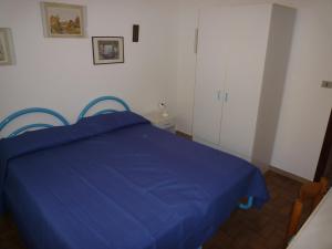 リド・ディ・イエゾロにあるVilla Mariucciaの白い壁のドミトリールームの青いベッド1台分です。