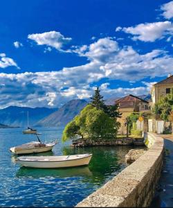 two boats are docked in a body of water at Spacious two bedroom apartment with free parking in Dobrota