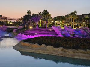 a park with purple lights in the water at night at Blue Bay Asia El Sokhna Aqua Park in Ain Sokhna
