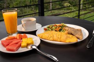 a table with two plates of food and a cup of orange juice at Cabañas Vista Verde opción sin jacuzzi in San Vito