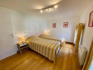 a bedroom with a bed and a table with a lamp at St THOMAS in La Teste-de-Buch