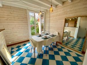 a dining room with a table and chairs on a checkered floor at St THOMAS in La Teste-de-Buch