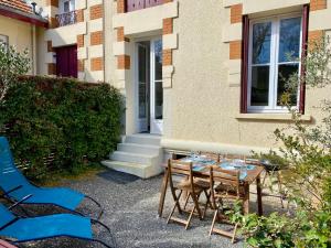 a table and chairs in front of a building at St THOMAS in La Teste-de-Buch