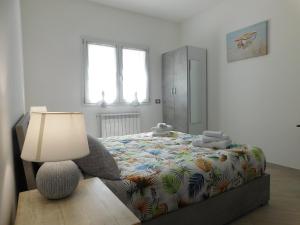 una camera da letto con un letto con una lampada su un tavolo di Lovely PitStop Fiumicino a Fiumicino