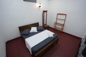 ジャフナにあるKCS HOLIDAY INN Pvt Ltdのベッドと椅子のある寝室