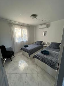a bedroom with two beds and a chair at Villa Namasté in Méjannes-lès-Alès +34 photos