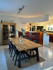 a wooden table in a living room with a kitchen at Villa Namasté in Méjannes-lès-Alès