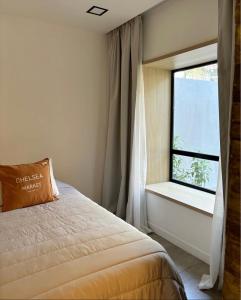 ein Schlafzimmer mit einem Bett und einem Fenster in der Unterkunft La Cayetana in Mar del Plata