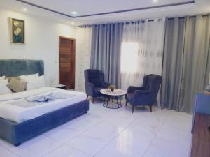 达喀尔Bi-Hotel 1的一间卧室，里面有一张床、两把椅子和一张桌子