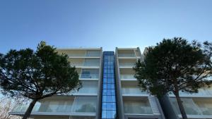 a tall building with trees in front of it at CN003 - Cesenatico, bilocale fronte mare con terrazzo panoramico in Cesenatico