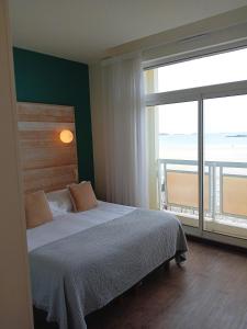 a bedroom with a bed with a view of the ocean at Alba hotel in Saint Malo +33 photos