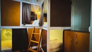 a small room with a bunk bed and a ladder at Pathfinder's Nest Hostel in Darjeeling