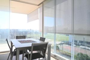 a dining room with a table and chairs and a large window at CN003 - Cesenatico, bilocale fronte mare con terrazzo panoramico in Cesenatico