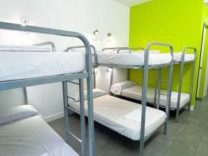 3 literas en una habitación con una pared verde en UBA Hostel, en San Sebastián