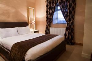 a bedroom with a large bed and a window at Bellbridge Cottage in Milltown Malbay