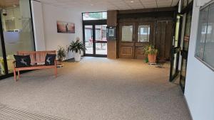 an office lobby with a bench and doors and plants at Schanzenblick mit Sauna und Pool in Schonwald im Schwarzwald +27 photos