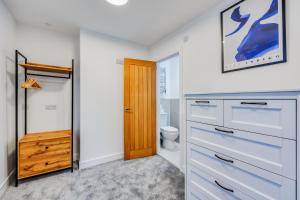 ein Badezimmer mit weißen Schränken, einem WC und einer Holztür in der Unterkunft 4 Bedroom 4 Bathroom House - Sleeps 7 - Prime Location, Free Parking, Self-Check-In, Workspace, Fast Wifi and Smart TV with Virgin TV and Netflix by Yoko Property in Northampton + 28 Fotos
