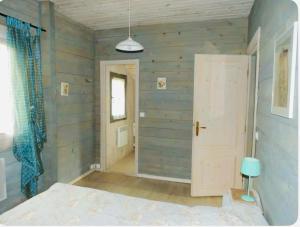 a bedroom with wooden walls and a white door at Les Chalets de Meilhac in Meilhac
