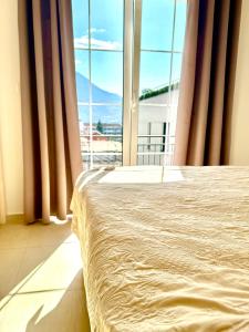 a bedroom with a bed and a large window at Spacious two bedroom apartment with free parking in Dobrota