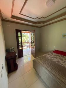 1 dormitorio con 1 cama y puerta al porche en acomodações hilton 100, en Ipueiras