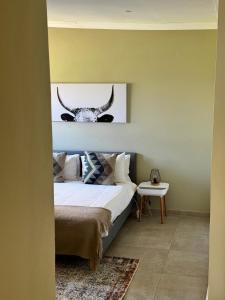 a bedroom with a bed with horns on the wall at Rosetta Fields Country Lodge in Rosetta