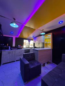 uma cozinha com luzes roxas no tecto em Studio de Luxe avec Jacuzzi à 15 Minutes de l'Aéroport AIBD ! em Déni Diarke