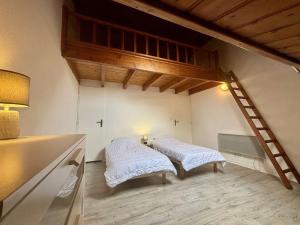 a room with two beds in a room with a ladder at Appartement 3 pièces 4 couchages Saint Trojan les Bains STO000-556 in Saint-Trojan-les-Bains