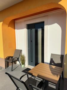 d'une terrasse avec une table en bois et 2 chaises. dans l'établissement Studio apartman Mango, à Jadranovo