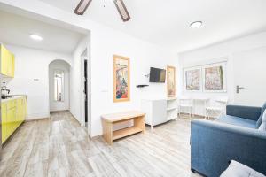 Una sala de estar con un sofá azul y una cocina. en FRUCT Pirata Beach, en Maspalomas