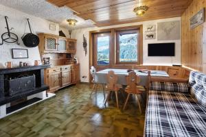 a kitchen with a table and chairs and a fireplace at Nido Alpino Terme e Sport - Bormio in Valdidentro