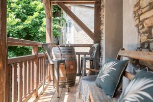 a porch with chairs and a table and a barrel at Le Cellier & Spa in Saint-Maximin