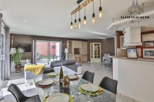 una cucina e un soggiorno con tavolo e sedie di Villa LS - Agreable Villa avec piscine et jacuzzi a Les Sables-dʼOlonne