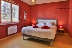una camera da letto con pareti rosse e un letto con due asciugamani rossi di Villa LS - Agreable Villa avec piscine et jacuzzi a Les Sables-dʼOlonne