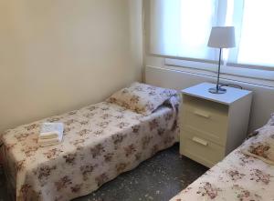a small bedroom with two beds and a night stand at Apartamento Francás in Comarruga +16 photos
