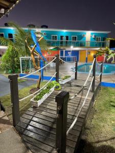 a resort with a blue bird sitting on a wooden staircase at Pousada do mineiro in Cabo Frio