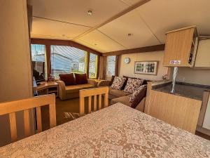 a kitchen and living room with a couch and a table at Stunning 6 Berth Caravan At Dovercourt Holiday Park, Essex Ref 44606O in Great Oakley