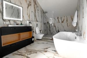 a bathroom with a tub and a sink and a toilet at Elysium House in Truskavets