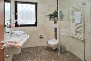 ein Badezimmer mit Toilette, Waschbecken und Dusche in der Unterkunft Hotel Zur Wildtränke in Spremberg + 19 Fotos