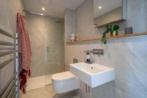 a bathroom with a white sink and a toilet at 3 Bedroom Luxury Waterside House in Hayle +22 photos